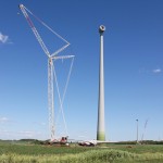 Vue d’une éolienne avec, au sol, les pales installées sur le rotor